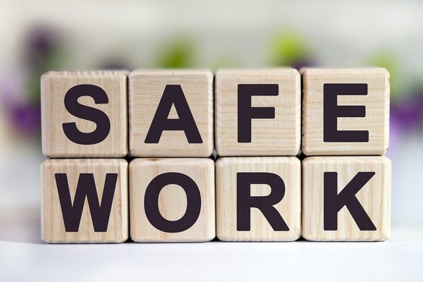 Holzwürfel, auf denen "Safe Work" - sichere Argbeit - steht