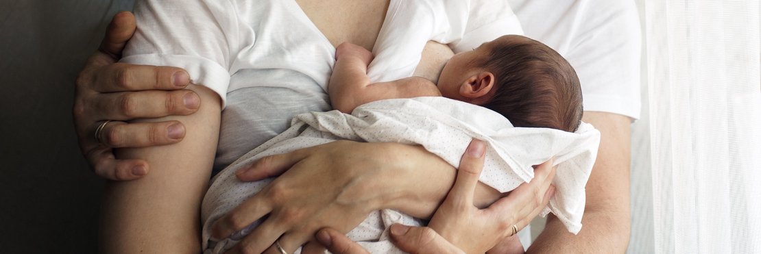 dekorativ, Eltern mit Ihrem Neugeborenen im Arm, Mutter stillt