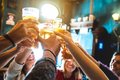 Jugendliche prosten sich mit Biergläsern bei gestreckten Armen zu