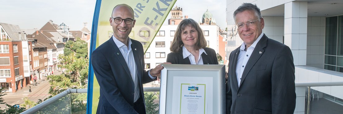 Hans-Jürgen Petrauschke mit Petra Koch und Kreissprecher Benjamin Josephs halten Fairtrade-Urlunde