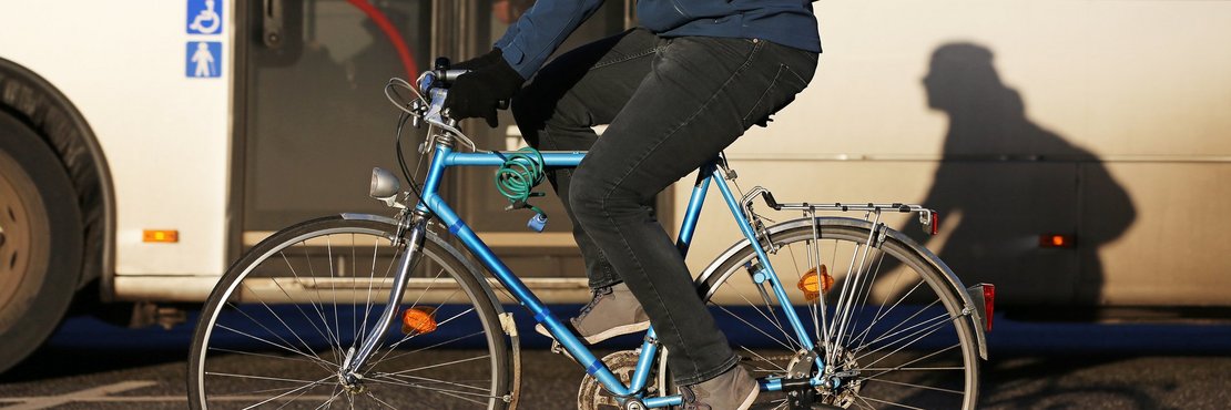 Symbolbild: Fahrrad vor Bus im Straßenverkehr