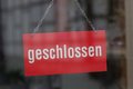 Schild hinter Glasscheibe: Geschlossen