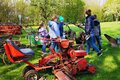 Kinder und Betreuerin schauen sich landwirtschaftliche Maschinen auf einer Wiese an