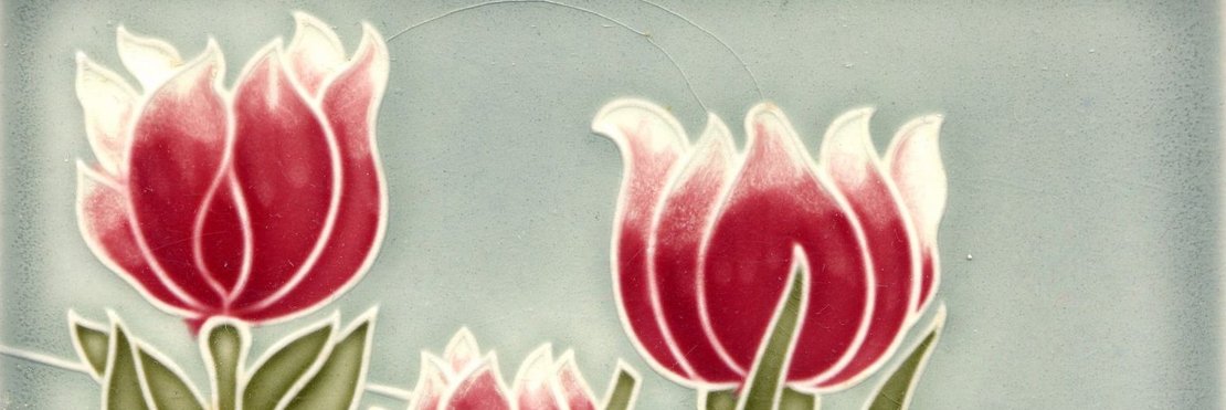 Jugendstilfliese mit Tulpen. Die Tulpen besitzen eine rote Blüte und einen grünen Stengel. Der Hintergrund ist blau. 
