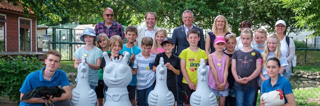 Foto vom Erlebnistag auf dem Wissenschaftlichen Geflügelhof: Kinder der GGS Frixheim mit Landrat Hans-Jürgen Petrauschke, Bürgermeister Dr. Martin Mertens, der Künstlerin Bertamaria Reetz (2.v.r. hinten), Dr. Mareike Fellmin (3.v.r. hinten), Saskia Neukirchen (vorne rechts) und Arne Kutsche (vorne links)