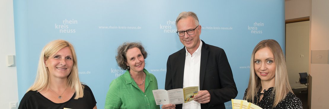 Magdolna Weitz, Christiane Taylor, Kreisdirektor Dirk Brügge und Alla Laptev stehen vor einer blauen Wand