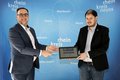 Zwei männliche Personen im Anzug vor einer blauen Wand halten gemeinsam ein Tablet auf dem das Open Data Portal zu sehen ist.