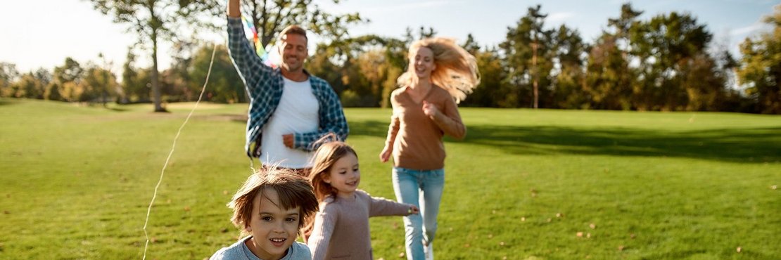 Eine Familie beim Drachensteigen lassen.