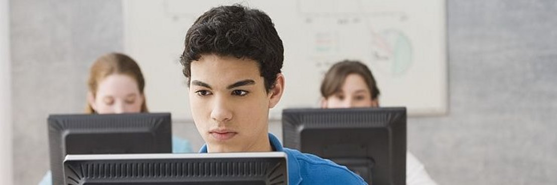 Jugendliche sitzen vor Computern