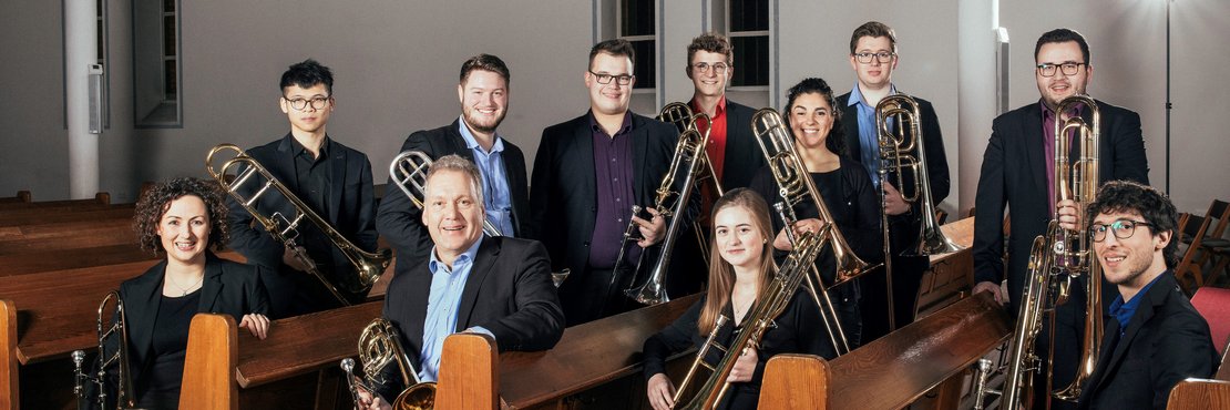 Personengruppe mit Musikinstrumenten auf Kirchenbänken