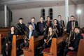 Personengruppe mit Musikinstrumenten auf Kirchenbänken