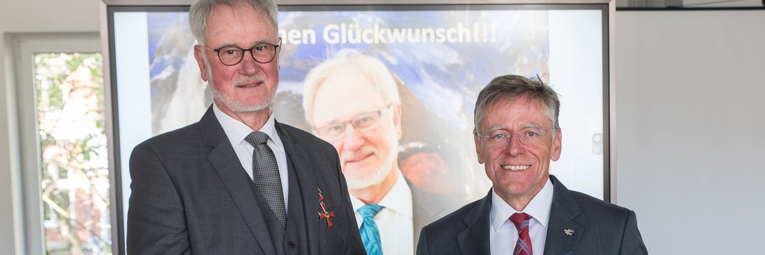 Landrat Hans-Jürgen Petrauschke und Hans Scholten halten eine Urkunde