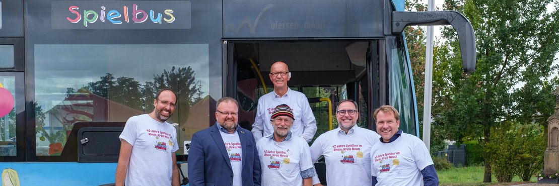 Gruppenfoto vor dem bunten Spielbus