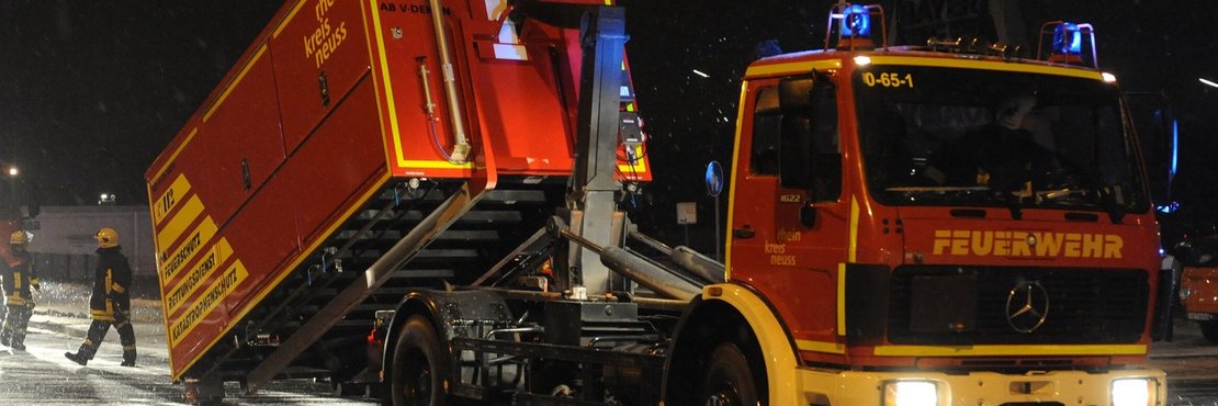 Wechsellader in Feuerwehr-optik setzt Container auf Straße ab