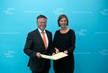 Eine männliche und eine weibliche Person halten eine Unterschriftenmappe