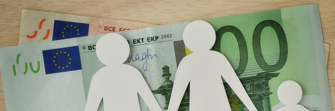 dekorativ, Euro Geldscheine mit Familie aus Papier im Vordergrund