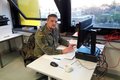 Soldat in Bundeswehr-Uniform sitzt am Schreibtisch vor Computer. 