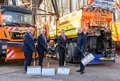 Gruppenfoto mit Schneeschaufeln vor Winterdienst-Fahrzeugen