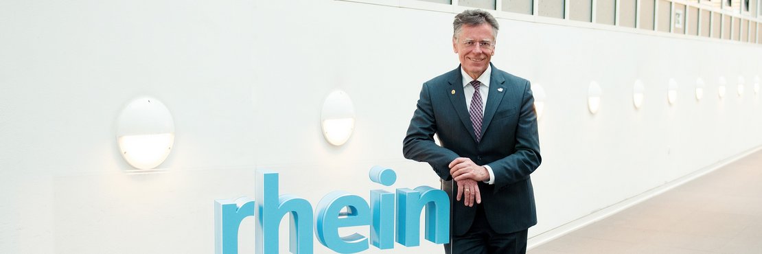 Landrat Hans-Jürgen Petrauschke lehnt an 3D-Logo des Rhein-Kreises Neuss