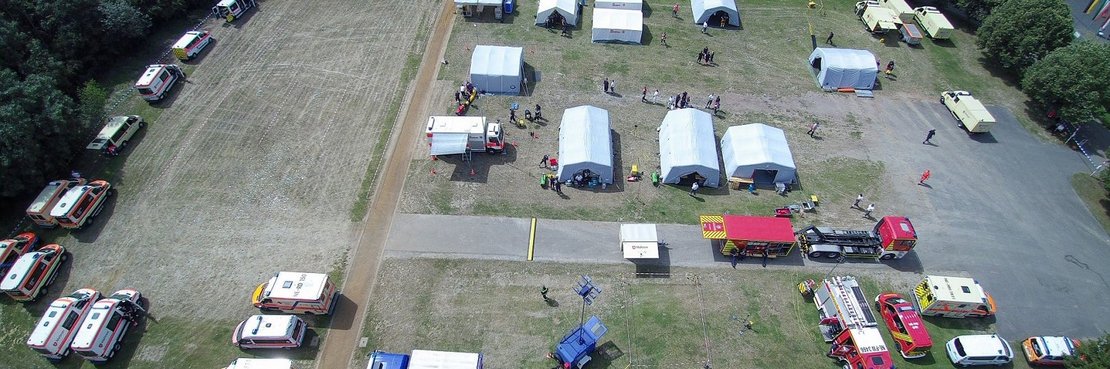 Luftbild eines Kirmesplatzes mit Einsatzfahrzeugen und Zelten