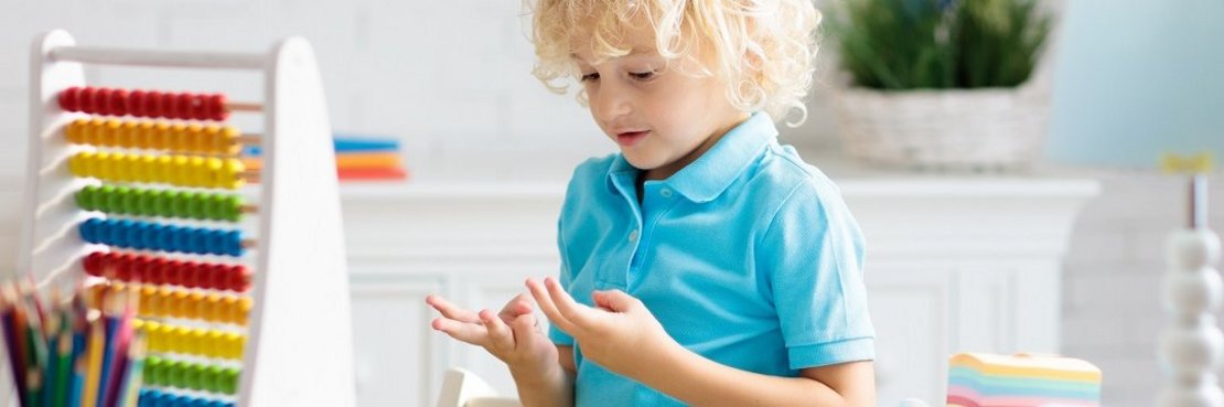 Kind rechnet mit Fingern und Rechenschieber