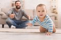 Männliche Person mit krabbelndem Baby