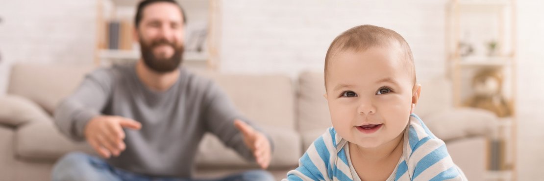 Männliche Person mit krabbelndem Baby