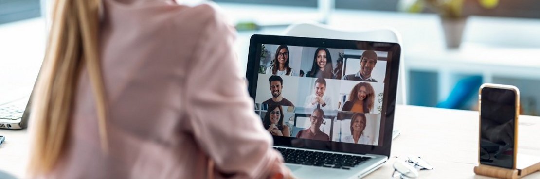 Dekorativ. Eine Frau sitzt vor einem Laptop mit laufender Video-Besprechung