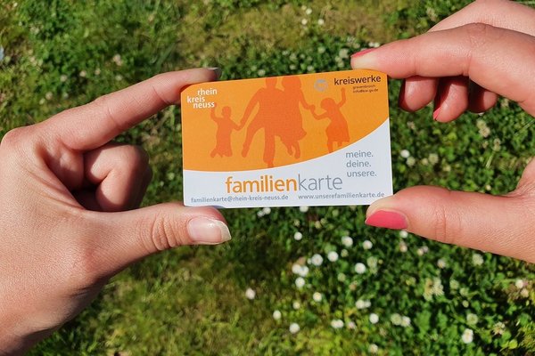 Zwei Hände halten die Familienkarte