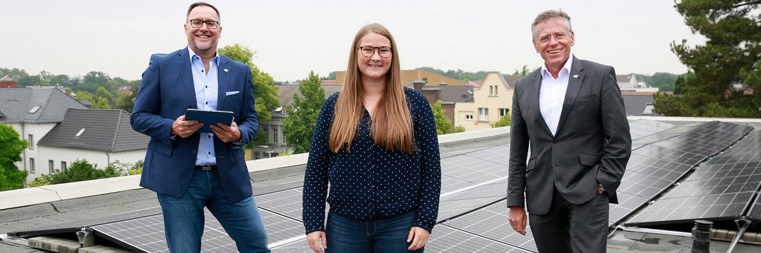 Baudezernent Harald Vieten, Architektin Anna-Elisa Schönauer und Landrat Hans-Jürgen Petrauschke stehen in Mitten der Photovoltaik-Anlage auf dem Dach des Kreisgesundheitsamts