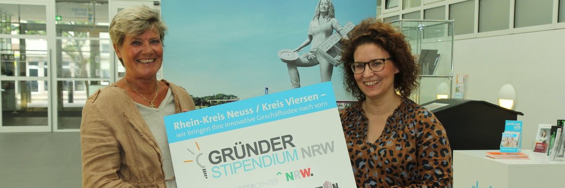 Hildegard Fuhrmann und Sarah Sorhagen halten Schild: "Gründerstipendium NRW"