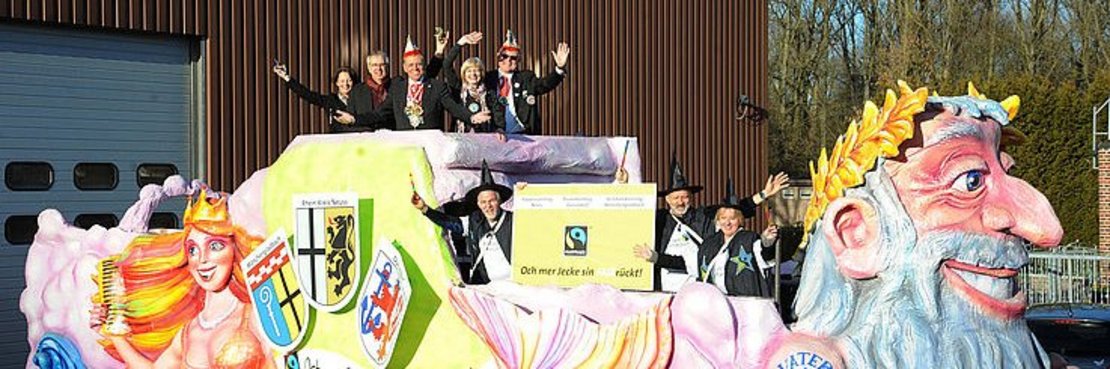 Fairtrade-Vorstandsvorsitzender Dieter Overath (2.v.l.), Landrat Hans-Jürgen Petrauschke (3. v.l.) und KA-Präsident Jakob Beyen (5. v.l.) freuen sich mit vielen Mitstreitern über den ersten Fairtrade-Karnevalswagen, der bei den Umzügen in Neuss, Düsseldorf und Mönchengladbach mitfährt