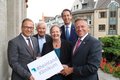 Personengruppe hält ein Schild mit dem Schriftzug "Rheinland Klinikum"