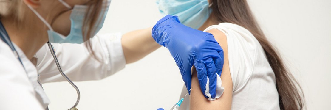 Symbolbild: Ärztin verabreicht Spritze in Oberarm einer jungen Frau