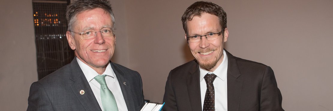 Landrat Hans Jürgen Petrauschke und Dr. Stephen Schröder mit Buch in der Hand