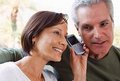 Ein Mann und eine Frau hören an einem Mobiltelefon