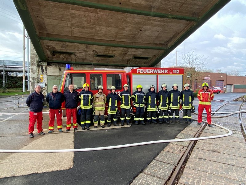 Feuerwehreinsatzkräfte: Gruppenfoto vor Feuerwehrfahrzeug