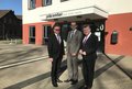 Landrat Hans-Jürgen Petrauschke, Jobcenter-Geschäftsführer Wolfgang Draeger und Bundestagsabgeordneter Hermann Gröhe stehen vor dem Jobcenter in Neuss.