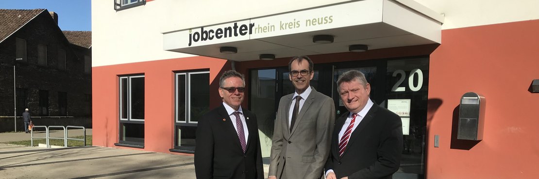 Landrat Hans-Jürgen Petrauschke, Jobcenter-Geschäftsführer Wolfgang Draeger und Bundestagsabgeordneter Hermann Gröhe stehen vor dem Jobcenter in Neuss.