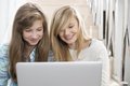 Zwei junge Frauen schauen auf ein Laptop
