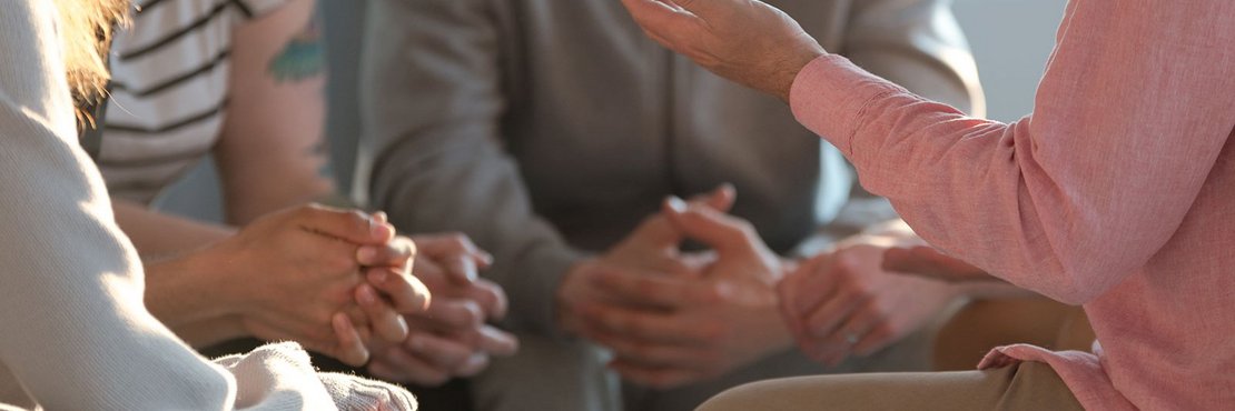 Symbolbild: 4 Menschen sitzen zusammen