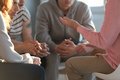 Symbolbild: 4 Menschen sitzen zusammen