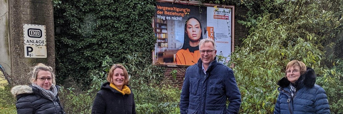 Sabine Raecher, die künftige Kreisgleichstellungsbeauftragte, Fleur König von der Frauenberatungsstelle Frauen helfen Frauen e.V. im Rhein-Kreis Neuss, Kreisdirektor Dirk Brügge und Gleichstellungsbeauftragte Ulrike Kreuels vor Plakatwand