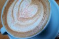 Tasse Kaffe mit Milchschaum, der mit einem Herz verziert ist.