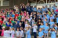 Foto von vielen Kindern auf einer Tribühne stehend
