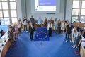 17 junge Menschen stehen im Halbkreis im Kreissitzungssaal in Grevenbroich. In der Mitte davor: Landrat Hans-Jürgen Petrauschke und Ruth Harte neben einer großen  Europafahne