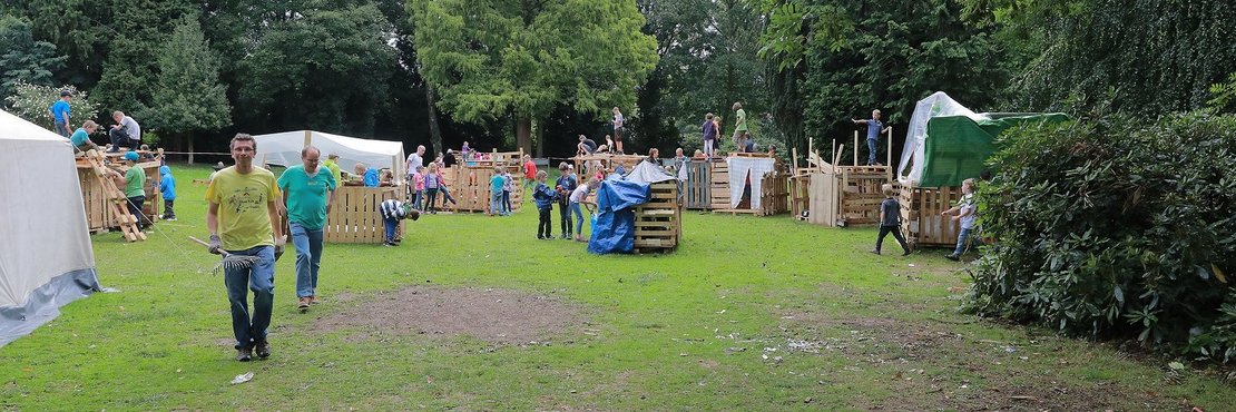 Ein Bauspielplatz mit Erwachsenen und Kindern