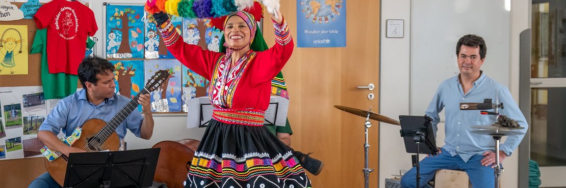 Schulkinder schauen peruanischer Tänzerin zu
