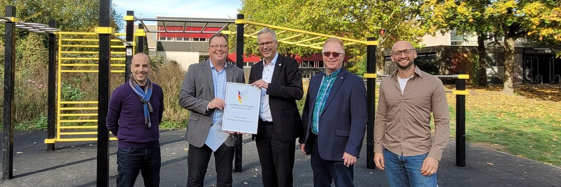 „Offizieller Kooperationspartner des Olympiastützpunkts Rheinland“: Jannis Dakos, Stefan Kremer, Kreisdirektor Dirk Brügge, Thomas Schütz und Andreas Aust am Gymnasium Norf.