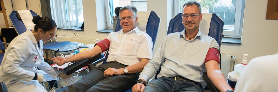 Zwei männliche Personen beim Blutspenden